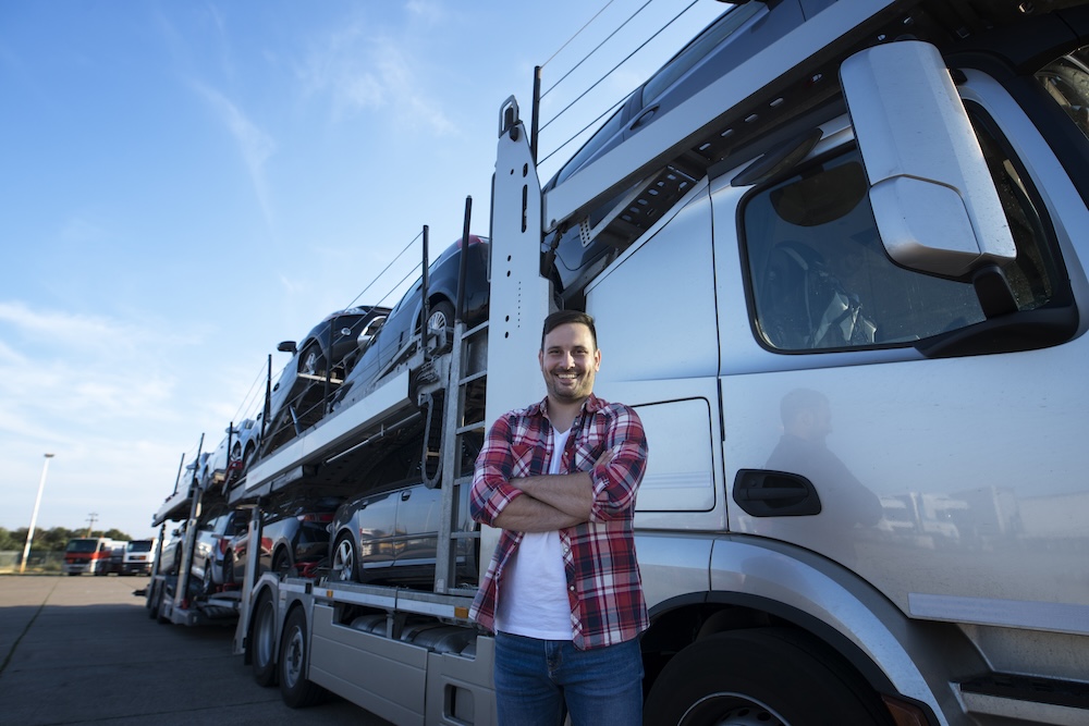 portrait-professional-smiling-truck-driver-with-crossed-arms-transporting-cars-market portrait-professional-smiling-truck-driver-with-crossed-arms-transporting-cars-market